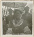 Woman wearing silver crown, with people in the background