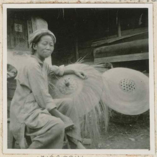 Woman pleating straw hats