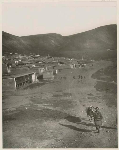 Lamasery, prayer wheels, and people on road