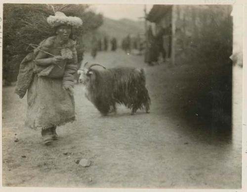 Woman standing outside next to sacred goat