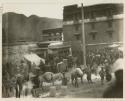 People, animals, and stalls outside in temple market