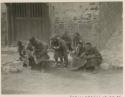 Men sitting on side of street