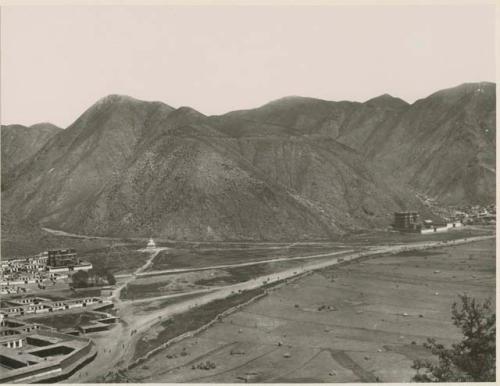 View of Labrang, Tibet showing lamasery, white stupa, and hills