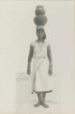 Tinguian woman balancing water vessels on her head