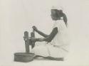 Tingian woman using cotton gin to make cloth