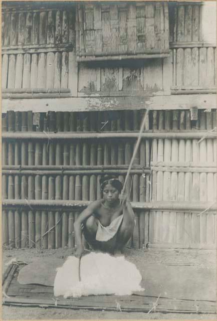 Tingian woman beating cotton for cloth