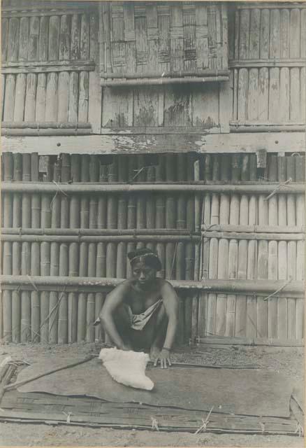 Tingian woman rolling beaten cotton