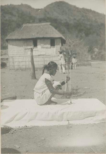 Tinguian woman winding cotton thread on a reel