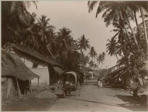 Road scene of people and cow drawn carriage