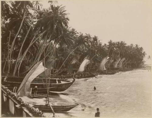 People and boats on shore