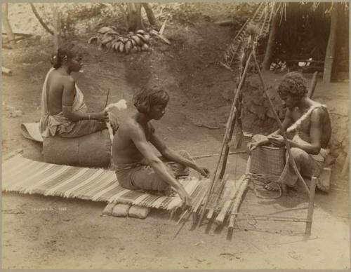 People weaving on loom