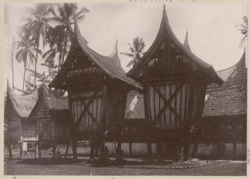 Thatched buildings with ornamented panels, some on stilts (longhouses)