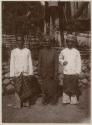 Three men dressed in traditional clothing outside