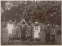 Posed line of children outside in traditional dress
