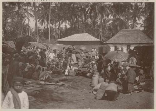 People, umbrellas, and bags and baskets outside, possibly a market