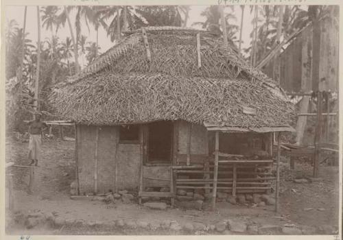 Thatched structure with food sitting on protruding covered window sill