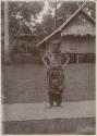 Man standing outside on a mat in traditional dress