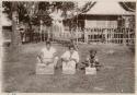 Three men sitting with wooden boxes