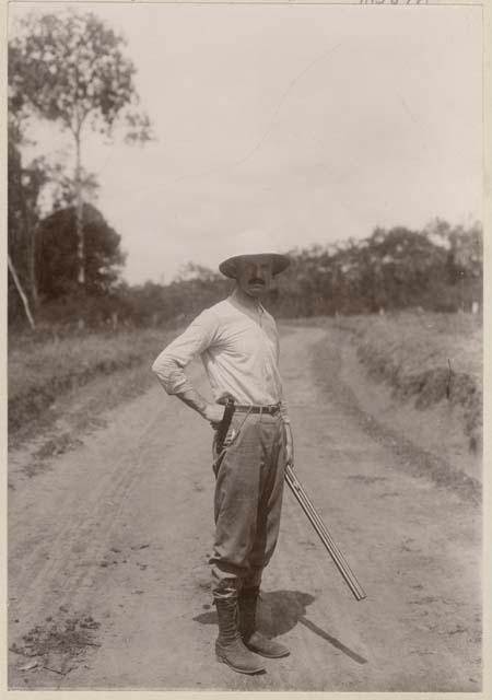 Man holding a gun standing in a road