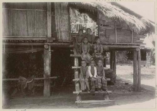 Group of children sitting on ladder in front of structure