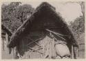 Building with thatched roof and large basket in front