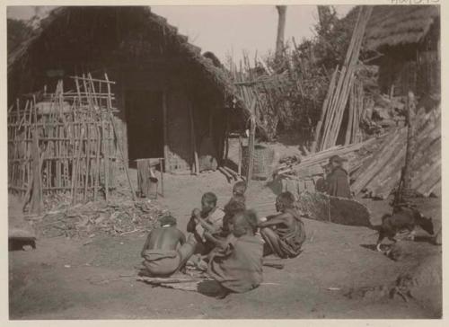 Group seated admist buildings and lumber