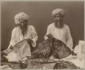 Two merchants with embroidered textiles