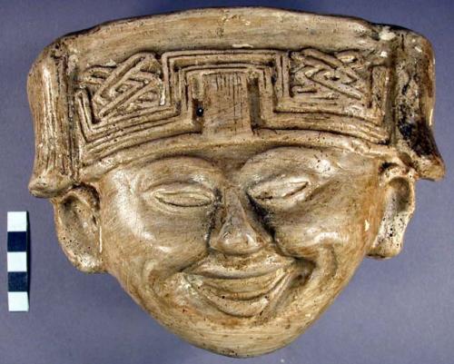 Cast of "laughing face" - geometric design in bas relief on forehead