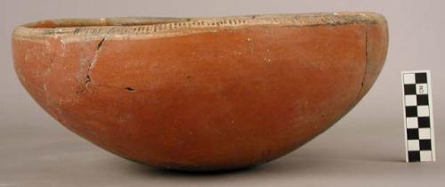 Restored red pottery bowl, rim decorated in black and white