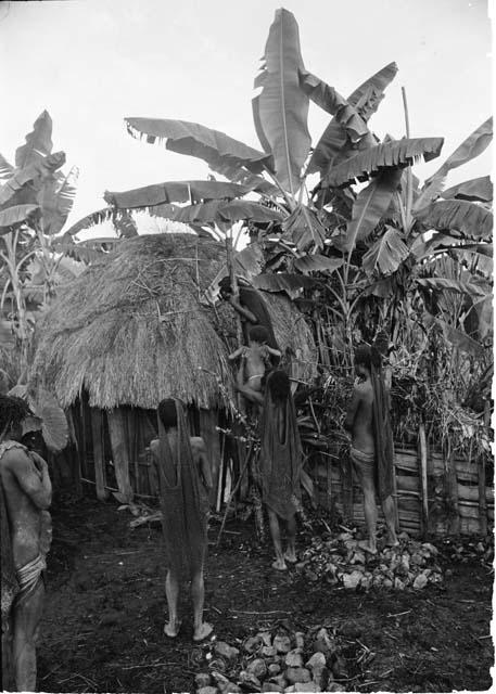 During a healing ceremony, Loliluk's ill wife is on a tripod and her child is handed to her