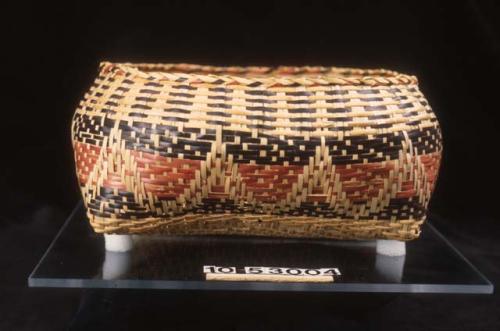 "Sewing basket" with pattern on exterior. Turtleneck in red, black, and natural