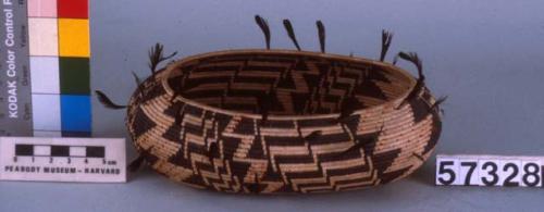 Oval coiled basket, natural with black complex geometric design.