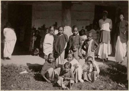 Group of women and children, men and other people in background