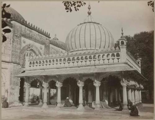 People sit outside ornately decorated building