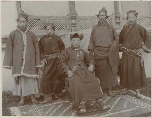 Lama Garu sitting on a chair with two disciples standing to either side