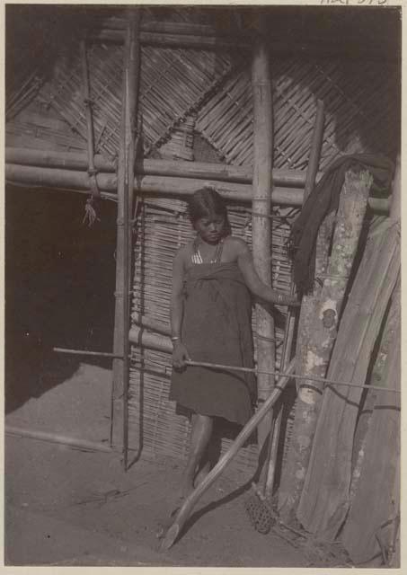 Woman between doorway and logpile