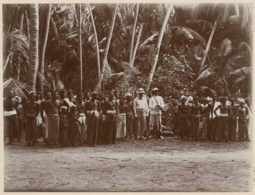 Group of people standing in front of palms