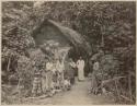 Women and children in front of hut in jungle