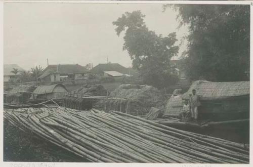 Piles of bamboo in front of buildings