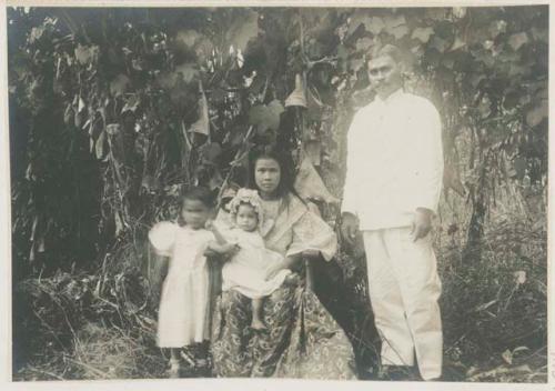 Man, woman, and children in front of vines