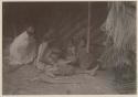 Woman working with a net, with a man and two children watching