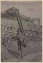 Man carrying bamboo poles in basket on his back