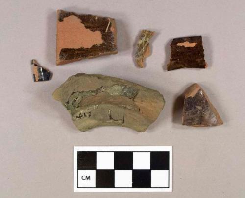 Four lead glazed redware body sherds; one lead glazed redware rim sherd; one lead glazed redware base sherd, burned