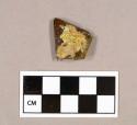 Glass, amber bottle glass fragment with gold paper label