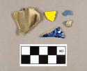 One blue hand painted pearlware body sherd; one flow blue pearlware body sherd; one blue annular banded pearlware body sherd; one yellow with red transfer print pearlware body sherd; one purple and green clouded Wheldon ware rim sherd