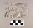 Two fragments of colorless bottle glass; one fragment of molded colorless bottle glass; one colorless glass rim fragment; one colorless glass rim fragment with etched floral design; two colorless glass folded rim fragments; four colorless glass handle fragments