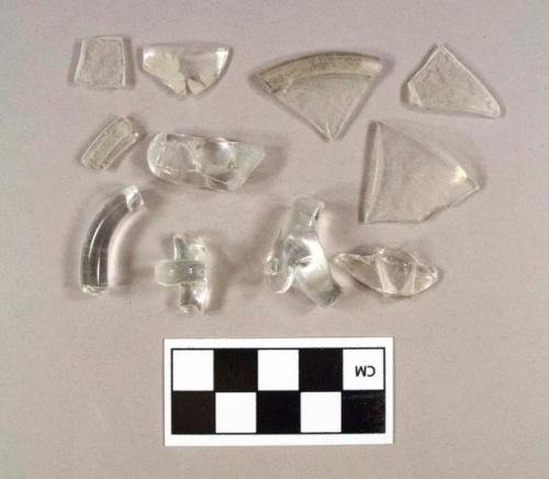 Two fragments of colorless bottle glass; one fragment of molded colorless bottle glass; one colorless glass rim fragment; one colorless glass rim fragment with etched floral design; two colorless glass folded rim fragments; four colorless glass handle fragments