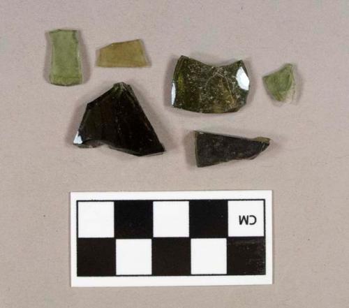 Five olive green bottle glass fragments; one olive green flat glass fragment