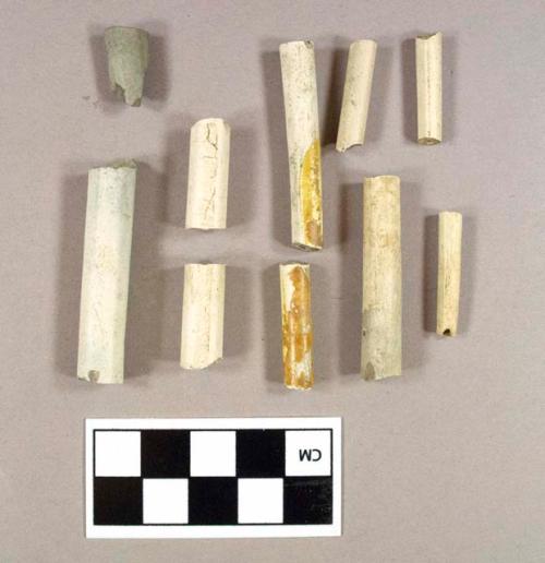 Three smoked pipe stem fragments; one unsmoked pipe mouthpiece fragment; two stamped unsmoked pipe stem fragments, maker's mark illegible, both cross mend; two yellow glazed unsmoked pipe stem fragments, both cross mend; 30 unsmoked pipe stem fragments; largest bore size is 6/64"