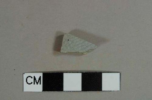 Refined eathenware body fragment, gray paste, unglazed ribbed on one side, black lead glaze on opposite side, likely jackfield type